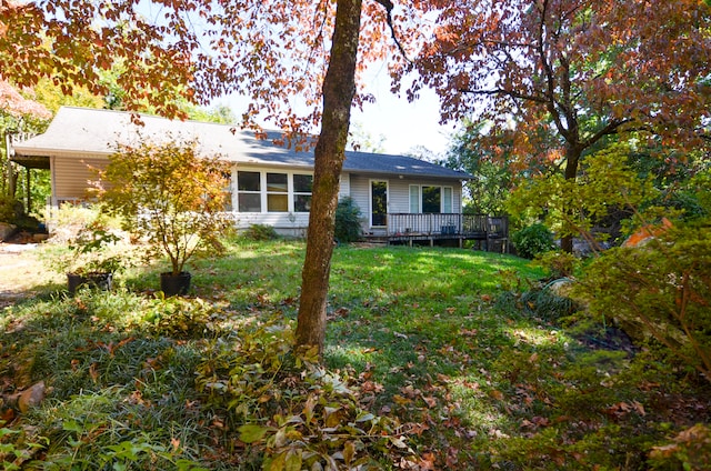 rear view of house with a deck and a lawn