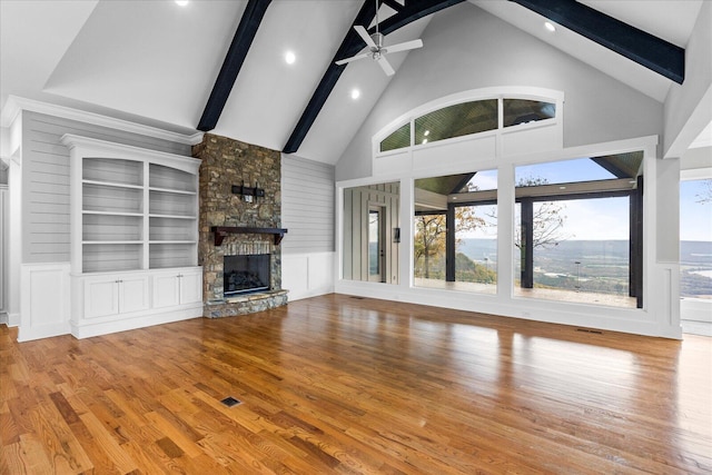 unfurnished living room featuring hardwood / wood-style floors, ceiling fan, a fireplace, and high vaulted ceiling