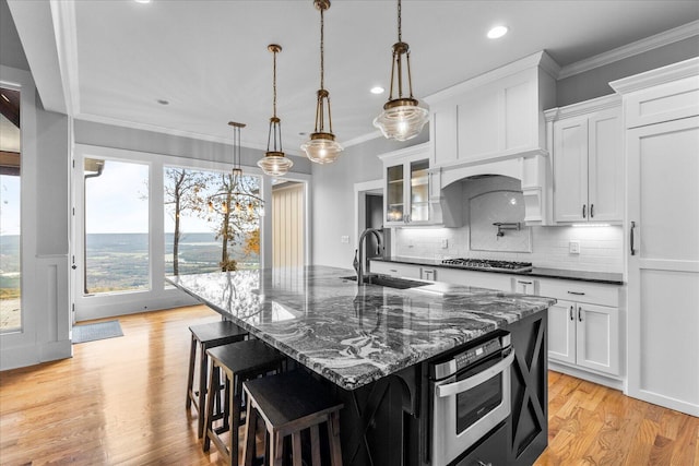 kitchen featuring appliances with stainless steel finishes, light hardwood / wood-style flooring, white cabinetry, and sink