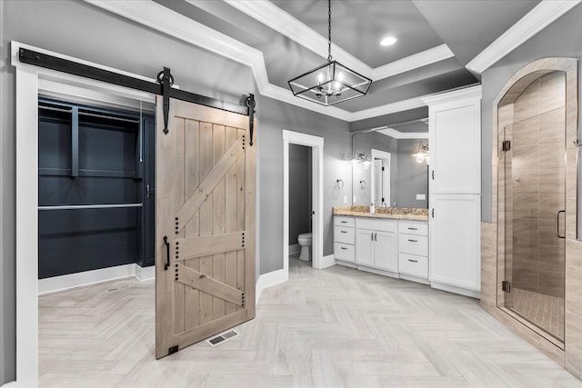 bathroom featuring parquet floors, crown molding, toilet, a shower with door, and vanity