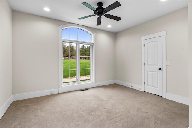 carpeted spare room with ceiling fan and a healthy amount of sunlight