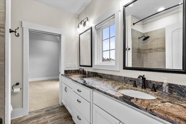 bathroom featuring a tile shower, vanity, and hardwood / wood-style flooring