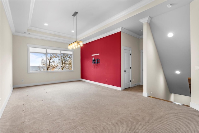 carpeted spare room featuring a notable chandelier, a raised ceiling, and crown molding