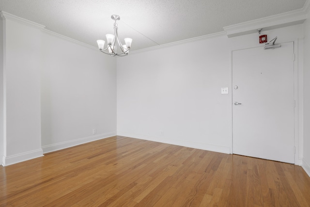 empty room featuring crown molding, a textured ceiling, and hardwood / wood-style floors