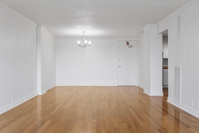 unfurnished room with a chandelier, crown molding, a textured ceiling, and light hardwood / wood-style floors