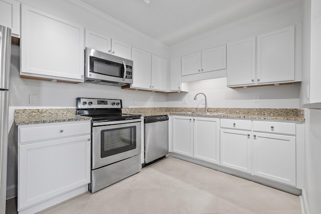 kitchen with sink, white cabinetry, stainless steel appliances, dark stone counters, and crown molding