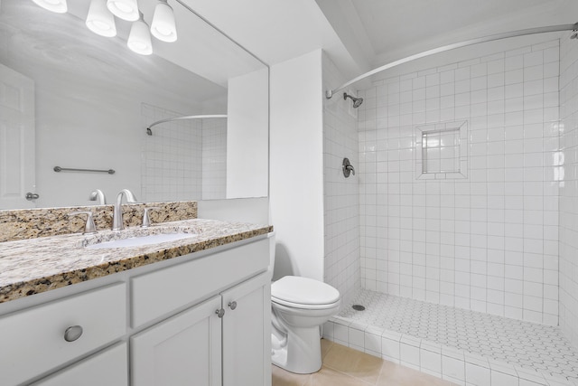 bathroom with vanity, toilet, tile patterned floors, and tiled shower