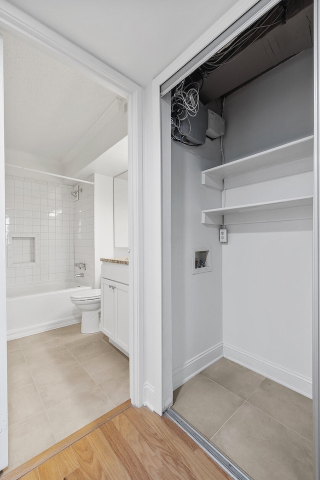 full bathroom featuring vanity, toilet, tiled shower / bath combo, and hardwood / wood-style floors