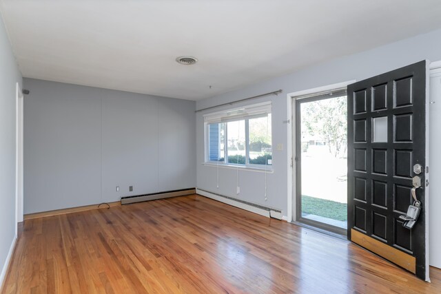 interior space featuring baseboard heating and light wood-type flooring