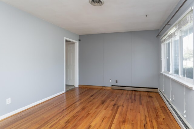 spare room featuring a baseboard radiator and light wood-type flooring