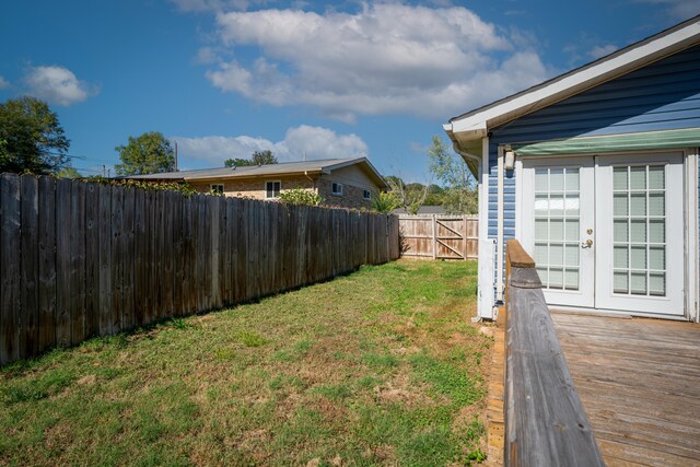 view of yard with french doors and a deck