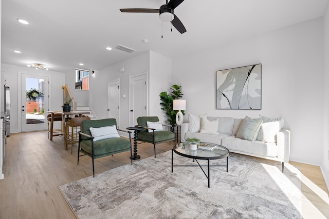 living room featuring ceiling fan and light hardwood / wood-style flooring