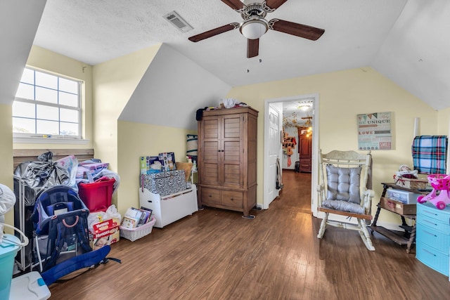 interior space featuring dark wood-type flooring, ceiling fan, a textured ceiling, and vaulted ceiling