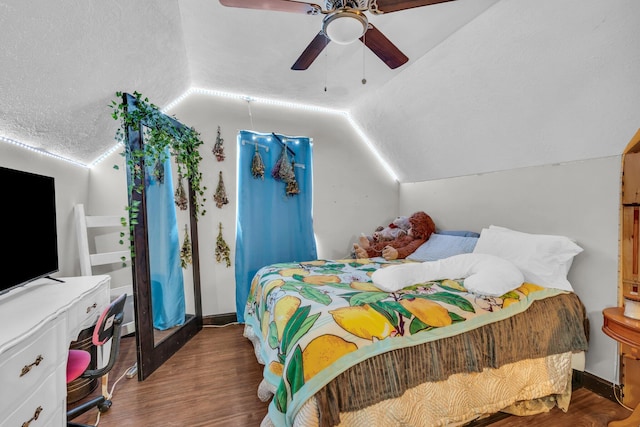 bedroom with a textured ceiling, ceiling fan, wood-type flooring, and vaulted ceiling