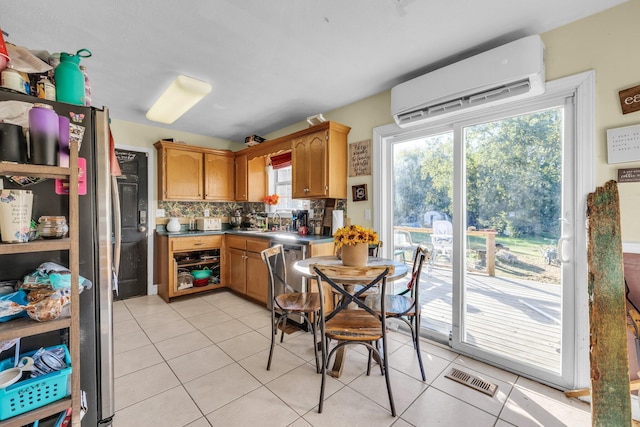 kitchen with sink, a wall mounted air conditioner, backsplash, stainless steel refrigerator, and light tile patterned floors