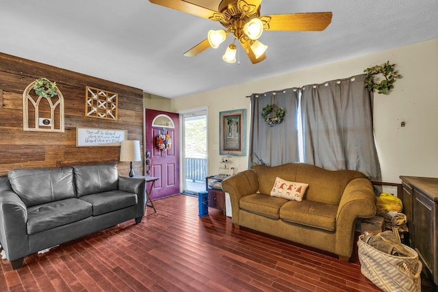 living room featuring wood walls, ceiling fan, and dark hardwood / wood-style flooring