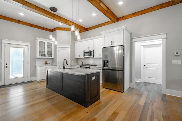 kitchen featuring white cabinetry, hanging light fixtures, stainless steel appliances, and light hardwood / wood-style floors