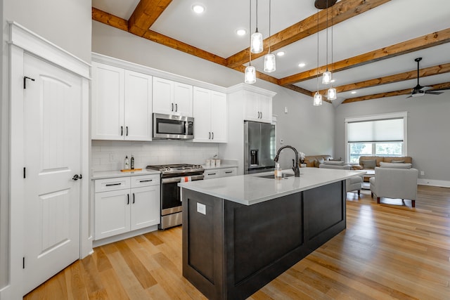 kitchen featuring sink, pendant lighting, white cabinets, and stainless steel appliances