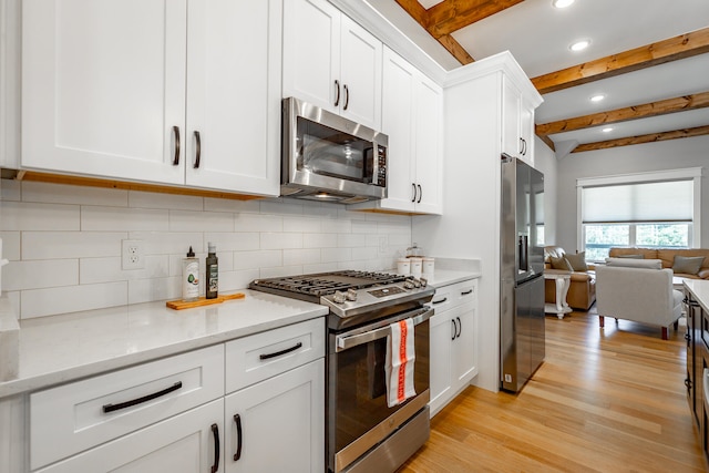 kitchen with white cabinetry, beam ceiling, and appliances with stainless steel finishes