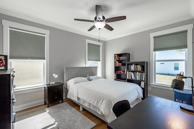 bedroom with ceiling fan, hardwood / wood-style flooring, and crown molding