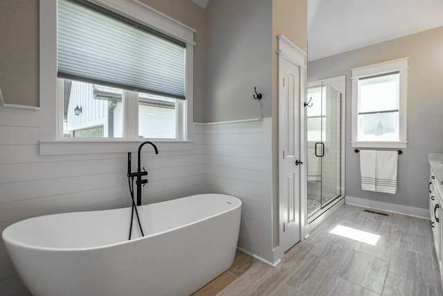 bathroom with vanity, independent shower and bath, and wood-type flooring