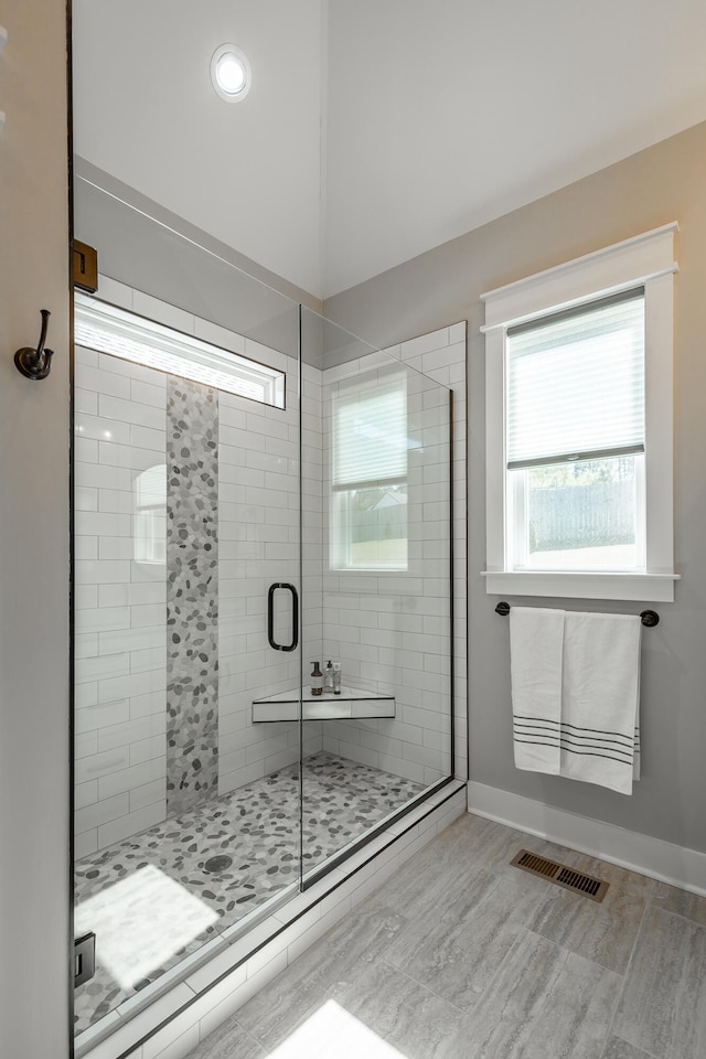 bathroom featuring a shower with door