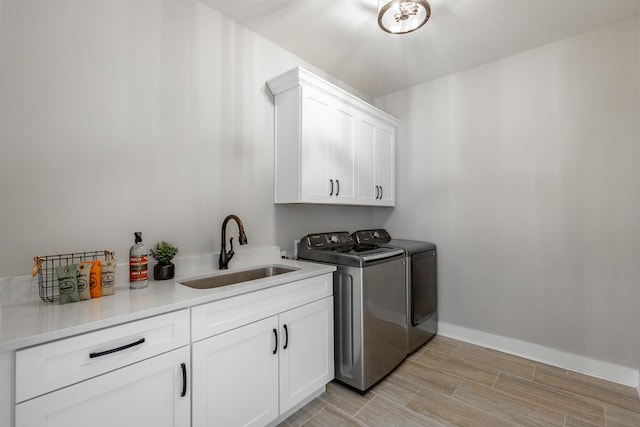 washroom featuring cabinets, sink, and separate washer and dryer