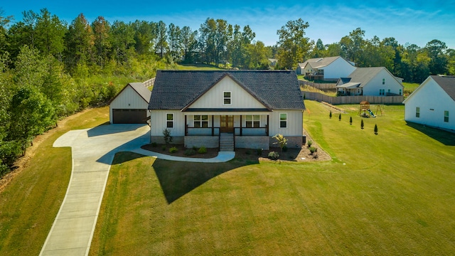 view of front of house with a front lawn, covered porch, and a garage