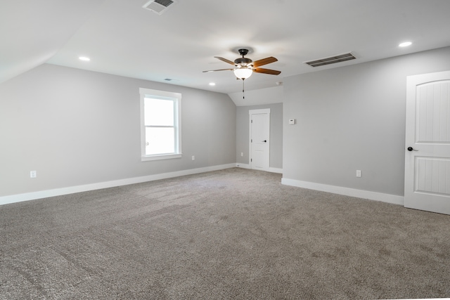 carpeted spare room featuring lofted ceiling and ceiling fan