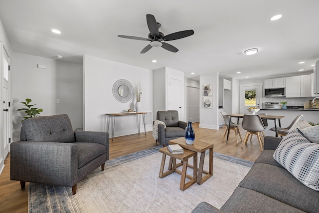 living room featuring ceiling fan and light wood-type flooring