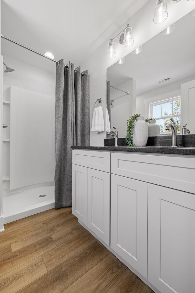 bathroom with vanity, wood-type flooring, and curtained shower