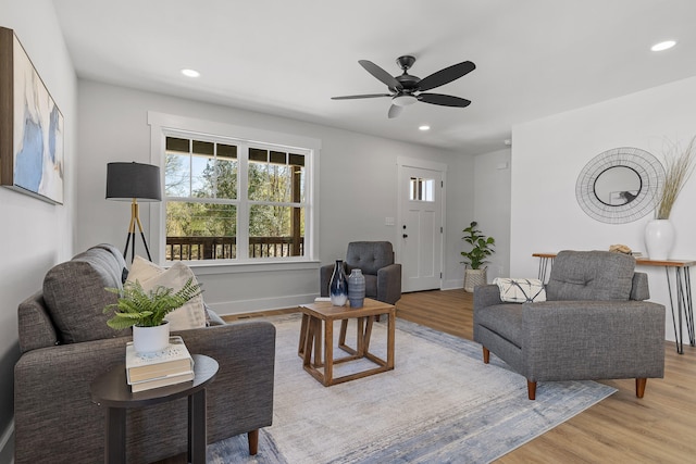 living room with ceiling fan and light hardwood / wood-style flooring