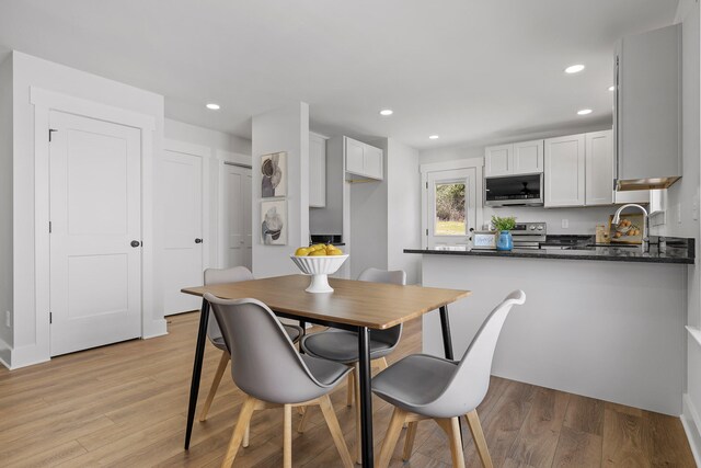 dining room with sink and light hardwood / wood-style flooring