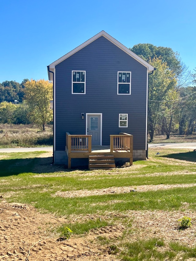 back of house with a deck and a lawn