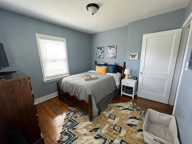 bedroom with dark hardwood / wood-style floors