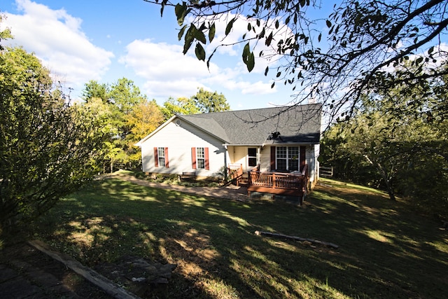 rear view of house with a lawn and a wooden deck