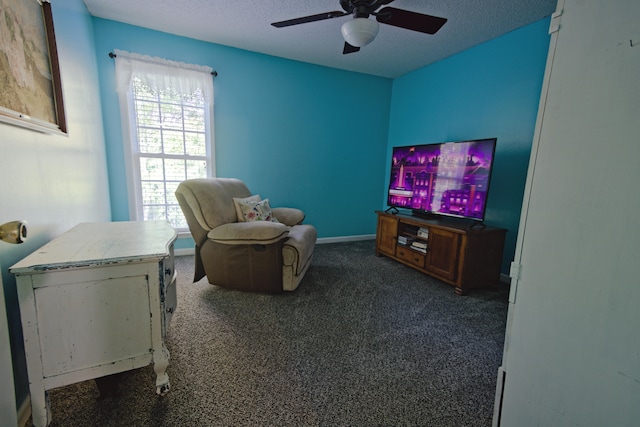 interior space with ceiling fan, dark carpet, and a textured ceiling