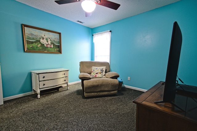 living area with dark colored carpet, a textured ceiling, and ceiling fan