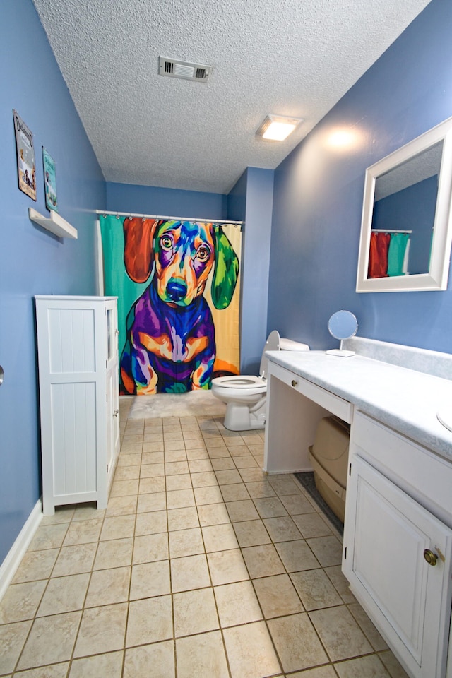 bathroom featuring tile patterned floors, a shower with curtain, vanity, a textured ceiling, and toilet