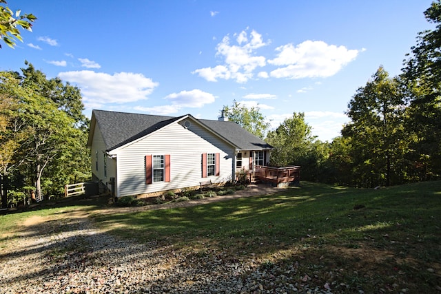 view of home's exterior featuring a yard and a deck