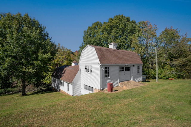 exterior space with an outbuilding, a garage, and a lawn