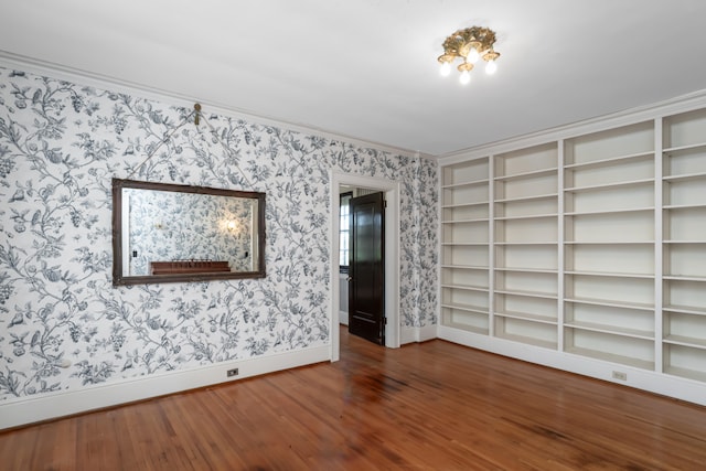 unfurnished room with crown molding and dark wood-type flooring