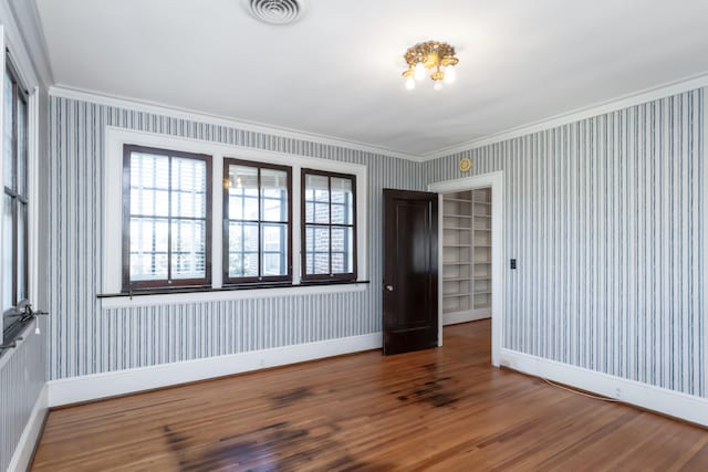 unfurnished room featuring ornamental molding and hardwood / wood-style flooring