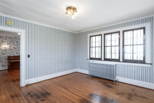 unfurnished room featuring radiator, crown molding, and dark hardwood / wood-style floors