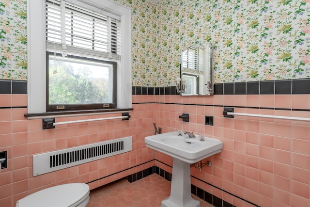 bathroom featuring tile patterned floors, tile walls, and toilet