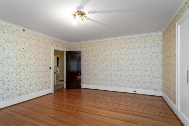 empty room with hardwood / wood-style flooring and crown molding