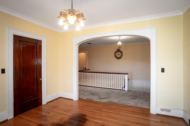 hallway featuring hardwood / wood-style floors, ornamental molding, and a chandelier