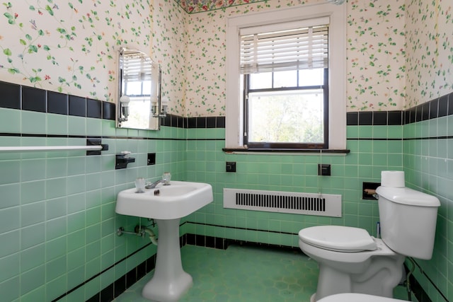 bathroom with toilet and tile walls