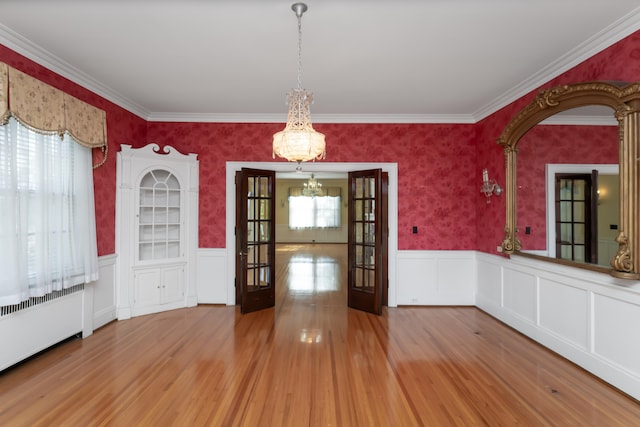 unfurnished dining area featuring french doors, plenty of natural light, and hardwood / wood-style floors