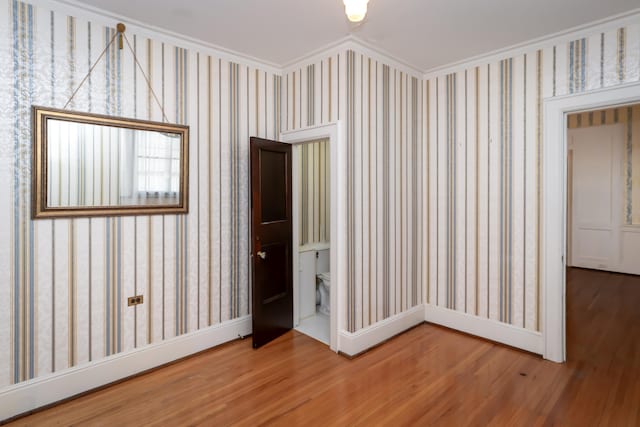 unfurnished room featuring wood-type flooring and ornamental molding